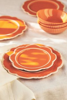 orange plates and bowls on a white table cloth