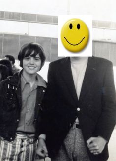 two people standing next to each other with a smiley face