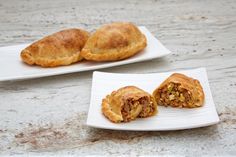 two small white plates with pastries on them