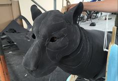 a black dog statue being worked on in a shop