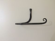 a black coat hook on the wall