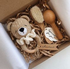 a teddy bear in a box next to a wooden spoon