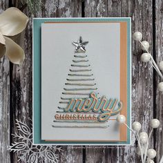 a close up of a christmas card with snowflakes and ornaments on a wooden surface