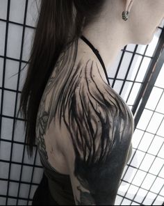 a woman with tattoos on her back and shoulder