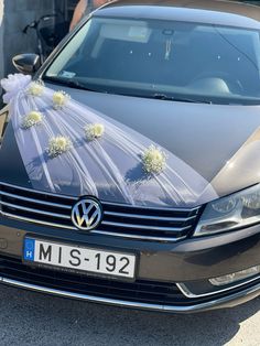 a car is decorated with flowers and ribbons for the bride's wedding day ceremony