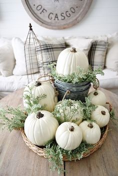 some white pumpkins in a basket on a table