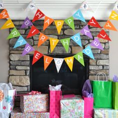 colorful birthday decorations and presents in front of a fireplace