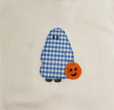 a white shirt with a blue and white checkered ghost applique on it