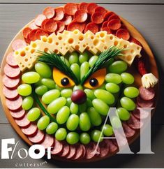 a platter with grapes, meats and cheese as the face of an animal