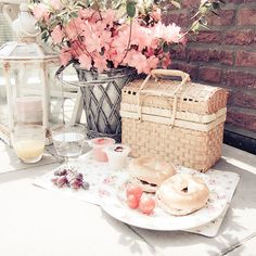 a table that has some flowers in a vase on it and other items around it