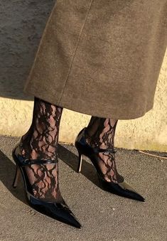 a woman's legs wearing black lace stockings and high heeled shoes with heels