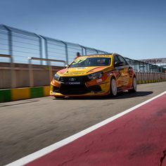 a yellow car driving down a race track