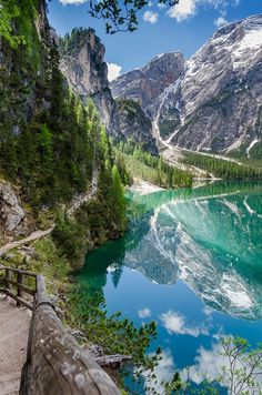 a scenic view of a mountain lake with clear blue water and green trees on both sides