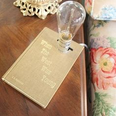 a wooden table topped with a lamp next to a couch