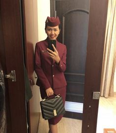 a woman in an airline uniform holding a cell phone