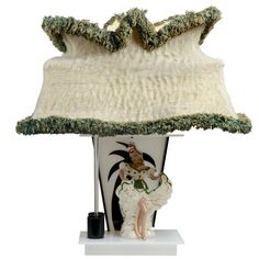 a table lamp with a white shade on it and a green trim around the base