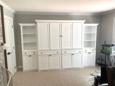 a living room with white cabinets and an aquarium