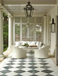 an outdoor living room with white furniture and checkered flooring