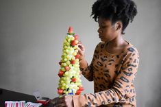 a woman is working on a sculpture made out of candy canes and other items