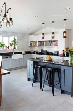 a large kitchen with an island and bar stools