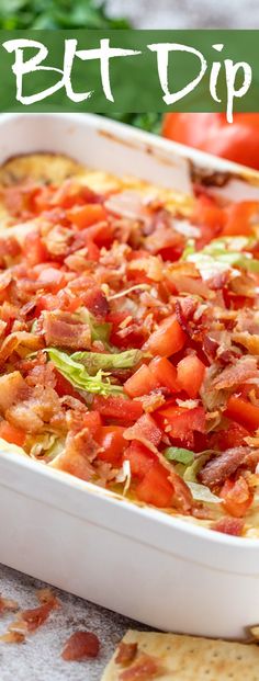 a casserole dish with bacon, tomatoes and lettuce in it next to tortilla chips