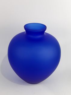 a blue vase sitting on top of a white table