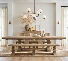 a dining room table and chairs with candles on the end tables in front of them