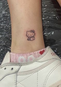 a small hello kitty tattoo on the ankle