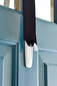 a door handle is attached to the side of a blue door with a black cloth hanging from it