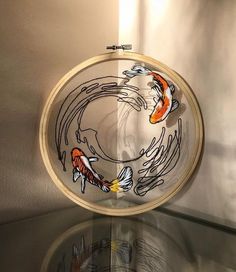 a glass table topped with a wooden frame filled with water and goldfish embroiderys