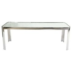 a glass and chrome dining table against a white background