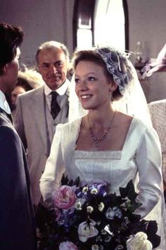 a woman in a wedding dress holding a bouquet