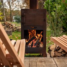 a wood burning stove sitting on top of a wooden deck next to chairs and firewood