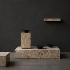 three pieces of marble are stacked on top of each other in front of a black wall