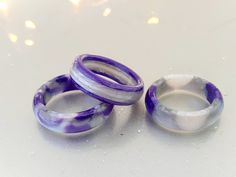 two purple and white rings sitting next to each other on top of a countertop