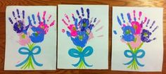 two handprints on paper with blue ribbon and pink flowers