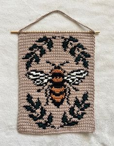 a crocheted wall hanging with a bee on it