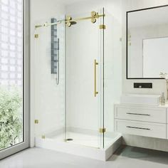 a bathroom with a walk in shower next to a white sink and mirror on the wall