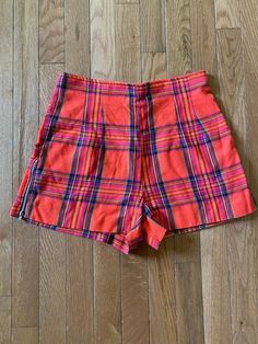 27" waist//Vintage 90s does 60s High Waist Plaid Shorts  Orange plaid shorts with zipper detail along the side of legs. Zipper up back.  Waist 27" Hips 38" Rise 13" Inseam 2" Length 13" Preppy twee professional retro Retro High-waisted Shorts With Belt Loops, Retro High Waist Shorts With Belt Loops, Retro Shorts With Belt Loops, Retro Shorts With Pockets, Retro Fitted Short Bottoms, Retro Short Leg Bottoms With Pockets, Retro Bottoms With Pockets And Short Legs, Vintage Shorts With Belt Loops, Retro Fitted Shorts