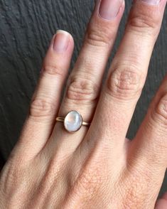 A beautiful luminescent white oval moonstone has been set in 14 karat gold with a handmade ring band from 14 karat gold half dome wire. The white moonstone changes colors when the light hits it going from a crisp white to having hues of blue, green, pink.  The stone is 10mm x 8mm in size. Made to order, please specify size when ordering! Each moonstone will vary in color, hues, and inner texture. Shipping included insurance. Insurance is required on all gold purchases.Moonstone is also the birth Moonstone Birthstone, White Moonstone, Half Dome, Ring Band, Fine Silver, Handmade Ring, Gold Ring, Moonstone, Birthstone