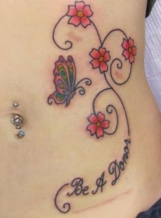 a woman's stomach with a butterfly and flower tattoo on the side, saying be a mom