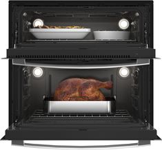 two ovens with one turkey in the middle and another on the bottom, both open