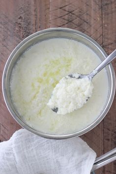 a metal bowl filled with white liquid and a spoon