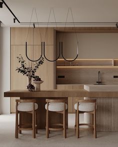 a modern kitchen with wooden cabinets and counter tops, along with bar stools that sit at the center of the room