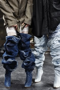 two people standing next to each other wearing boots