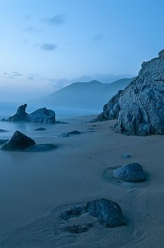 rocks and sand on the beach at dusk