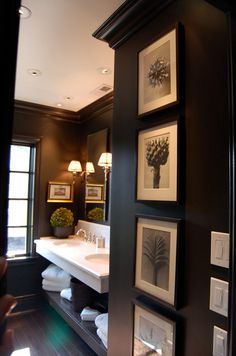 a bathroom with pictures on the wall and framed photos above it, along with other items