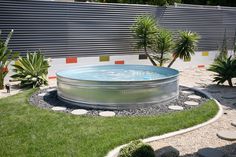 an outdoor hot tub in the middle of a garden