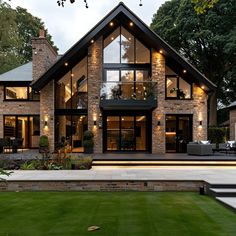 a large house with lots of windows and lights on it's front lawn area