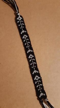 a black and white beaded bracelet sitting on top of a table